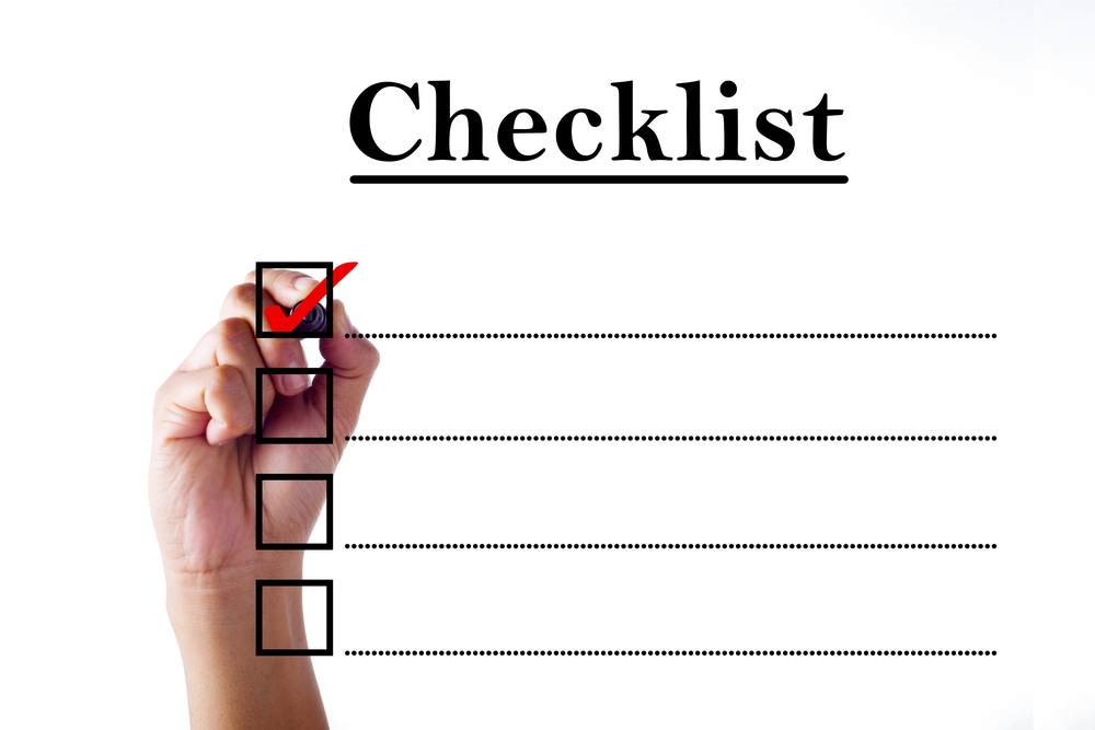 a man's hand writing a tick in a box on a checklist form
